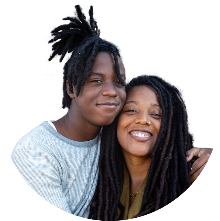 Two women hugging and smiling joyfully while taking a selfie together. 